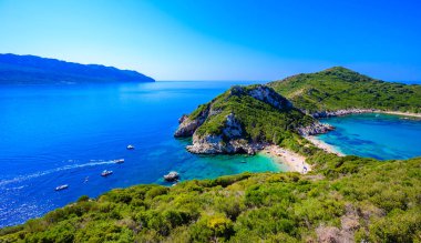 Porto Timoni 'nin Afionas plajı, Korfu, İyon adası, Yunanistan ve Avrupa' da kristal berrak gök mavisi suyu bulunan bir cennet çifte kumsalı.