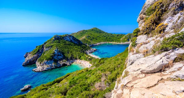 Porto Timoni 'nin Afionas plajı, Korfu, İyon adası, Yunanistan ve Avrupa' da kristal berrak gök mavisi suyu bulunan bir cennet çifte kumsalı.