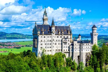 Neuschwanstein Şatosu 'nun güzel Alpler manzarasında arka planda Fuessen, Bavyera, Almanya yakınlarındaki Forggensee Gölü' nü görebilirsiniz.