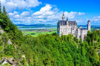 Neuschwanstein Şatosu 'nun güzel Alpler manzarasında arka planda Fuessen, Bavyera, Almanya yakınlarındaki Forggensee Gölü' nü görebilirsiniz.