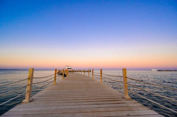 夕日と豪華なヨットでフルガダの紅海の木製の桟橋 遊歩道ボードウォークの眺め エジプト アフリカ — ストック写真