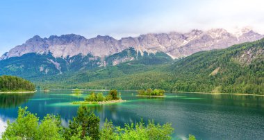 Eibsee Gölü 'nün ortasında Zugspitze Dağı' yla çam ağaçları olan küçük adalar. Cennet plajlı güzel manzara ve Alman Alpleri, Bavyera, Almanya, Avrupa 'daki berrak mavi su.