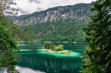 Eibsee Gölü 'nün ortasında Zugspitze Dağı' yla çam ağaçları olan küçük adalar. Cennet plajlı güzel manzara ve Alman Alpleri, Bavyera, Almanya, Avrupa 'daki berrak mavi su.