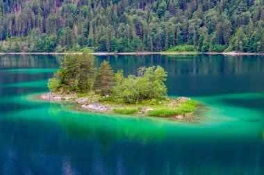 Eibsee Gölü 'nün ortasında Zugspitze Dağı' yla çam ağaçları olan küçük adalar. Cennet plajlı güzel manzara ve Alman Alpleri, Bavyera, Almanya, Avrupa 'daki berrak mavi su.