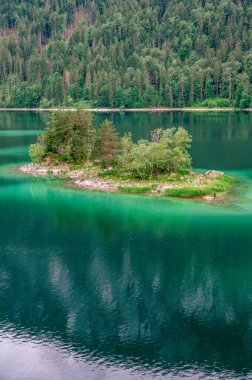 Eibsee Gölü 'nün ortasında Zugspitze Dağı' yla çam ağaçları olan küçük adalar. Cennet plajlı güzel manzara ve Alman Alpleri, Bavyera, Almanya, Avrupa 'daki berrak mavi su.
