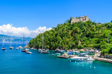 Portofino, İtalya 'daki Castello Brown liman kasabasında küçük körfezde renkli evleri ve yatları var. Liguria, Cenova bölgesi, İtalya. Yaz mevsiminde güzel deniz manzaralı İtalyan balıkçı köyü.