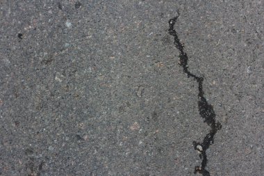 Gri asfalt çatladı. Gri dokular. Yolda beton asfalt çatlakları makro yakınçekim
