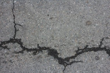 Gri asfalt çatladı. Gri dokular. Yolda beton asfalt çatlakları makro yakınçekim