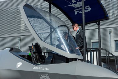 BERLIN, GERMANY - APRIL 26, 2018: Visitors look at the cockpit of the stealth multirole fighter Lockheed Martin F-35 Lightning II. US Air Force. Exhibition ILA Berlin Air Show 2018 clipart