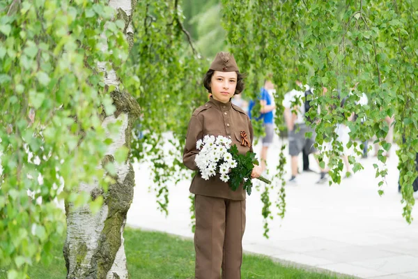 第2次世界大戦中の赤軍の兵士の制服に花を持つ少年の肖像 — ストック写真