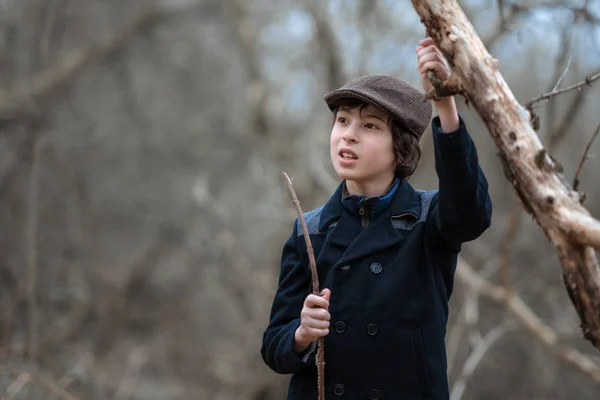 在大自然的背景下 一个穿着外套 戴着帽子的男孩的肖像 — 图库照片
