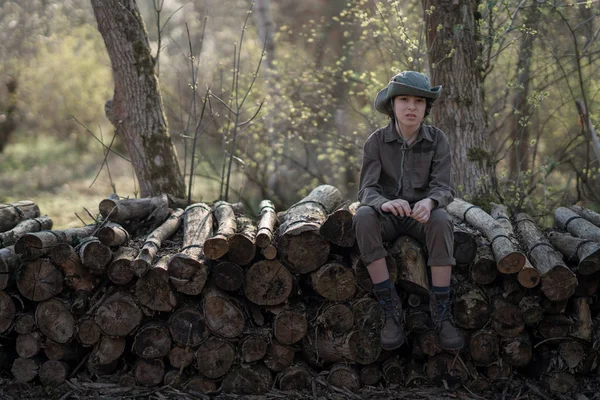 Boy Coveralls Hat Sitting Pile Sawn Logs Forest — Stock Photo, Image