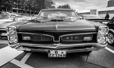 BERLIN - MAY 11, 2019: Muscle car Pontiac GTO, (first generation). Black and white. 32th Berlin-Brandenburg Oldtimer Day. clipart