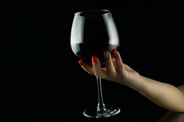 Şarap siyah arka planda tutan el