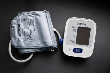 Vladivostok, Rusya - 17 Mayıs 2018: Omron tarafından karanlık bir arka plan üzerinde kan basıncı ölçümü için yapılan elektronik tonometer.