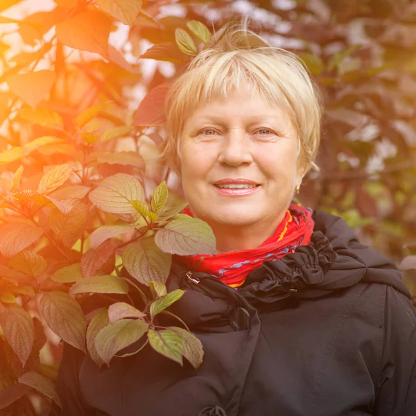 Açık havada güneş ışığı ile güzel bir orta yaşlı kadın portresi.