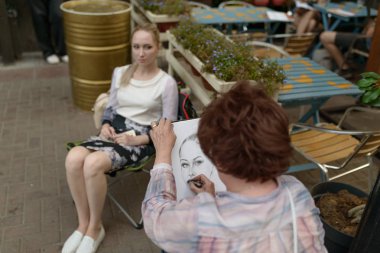 MOSCOW, RUSSIA - 23 Ağustos 2017: Sanatçı genç bir kadının portresini çiziyor.