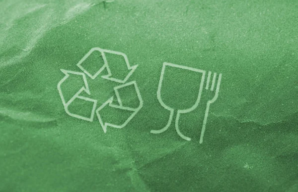 Green recycle logo on paper. Selective focus.