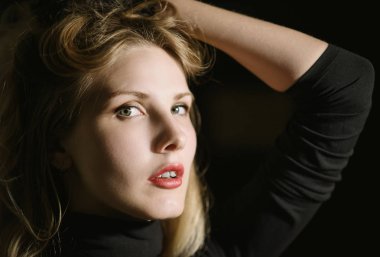 Koyu arkaplanda güzel bir genç kadının portresi.