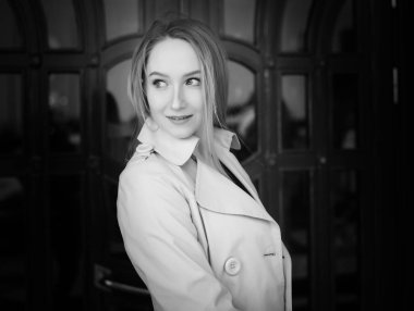 Siyah ve beyaz Beyaz paltolu güzel genç kadın portresi.