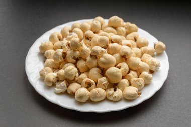 Beyaz karanlık bir arka plan üzerinde patlamış mısır yemek.