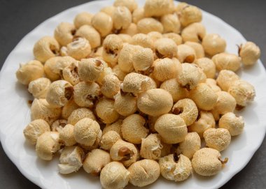 Beyaz karanlık bir arka plan üzerinde patlamış mısır yemek.