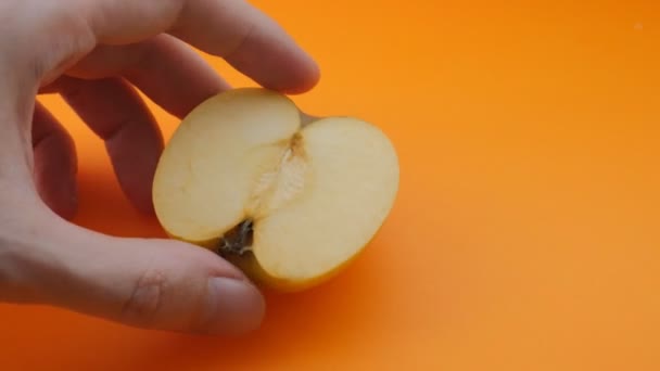 Рука Розрізає Яблуко Ножем Помаранчевому Фоні Повільний Рух — стокове відео