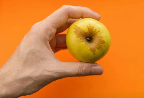 Maçã Mão Sobre Fundo Laranja Foco Seletivo Com Profundidade Campo — Fotografia de Stock