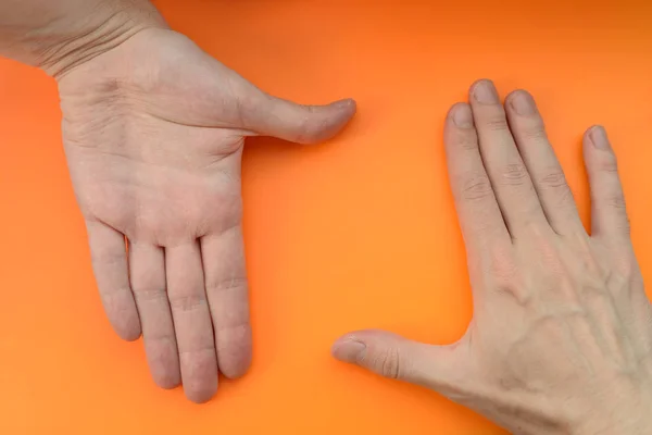 Manos Haciendo Marco Sobre Fondo Naranja —  Fotos de Stock