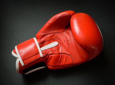 Koyu arka plan üzerinde eski ve kullanılan boks eldiveni.