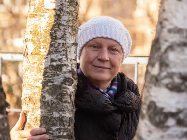 Güzel bir orta yaşlı kadın, açık havada portresi. Renk tonlu.