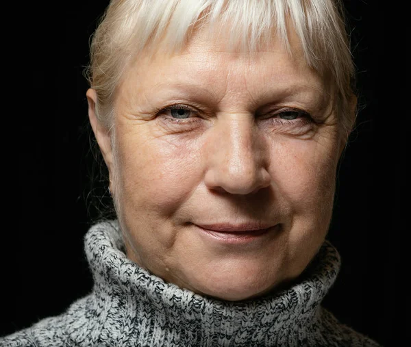 暗い背景にセーターの中年の女性の肖像画 — ストック写真