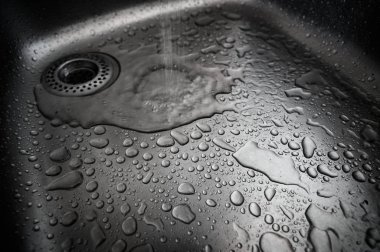 Metal yüzeye su damlaları. Sığ alan derinliğine sahip makro.