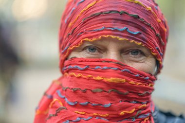 Kırmızı eşarplı orta yaşlı güzel bir kadının portresi..