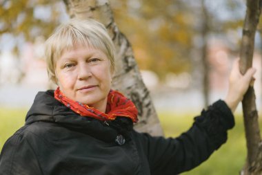 Açık havada orta yaşlı güzel bir kadının portresi. Seçici odak.