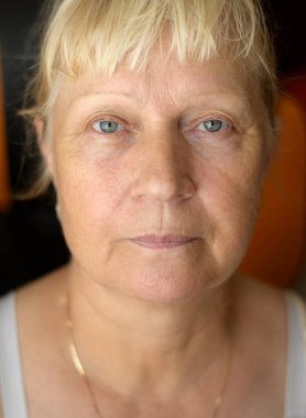 Mutfakta yaşlı bir kadının portresi. Sığ alan derinliğine sahip seçici odak.