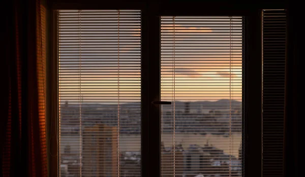 The sun shines through the blinds. Selective focus.