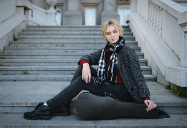 Paltolu güzel kız. Eski bir keman çantasıyla.