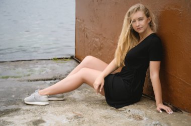 Elbiseli kadın deniz kıyısında yürümekten hoşlanıyor..