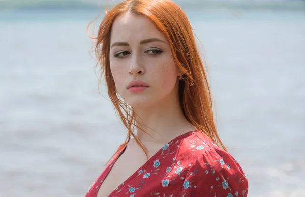 赤い頭の女性のドレスは海の海岸近くの散歩を楽しんでいる — ストック写真