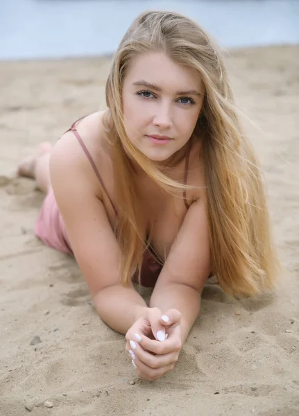 Νεαρή Γυναίκα Ροζ Φόρεμα Στην Άμμο Και Απολαμβάνει Θάλασσα — Φωτογραφία Αρχείου