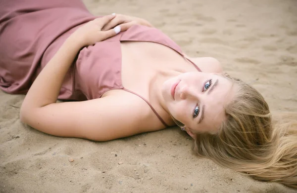 Jovem Mulher Vestido Rosa Deitada Areia Gosta Mar — Fotografia de Stock