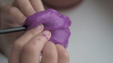 Küçük kız evde balçık denen oyuncakla oynuyor. Seçici odak.