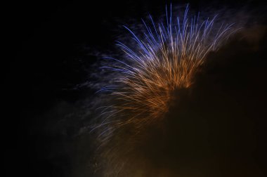 Gece şehrin üzerinde renkli havai fişekler.