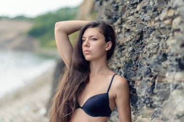 Güzel esmer kadın kayaların arasında.