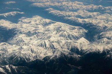 Dünya yüzeyindeki uçaktan görünüm - karla kaplı dağlar.