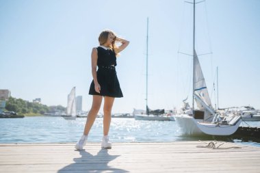 Elbiseli kadın iskelede denizi seviyor..