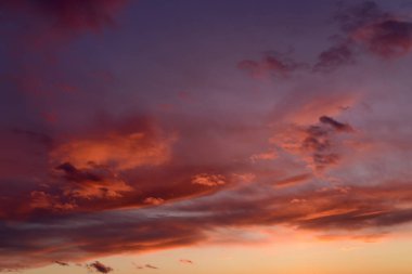 Turuncu renkli bulutlarla dramatik günbatımı gökyüzü.