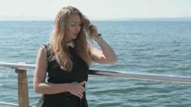 İskelede güzel bir kadın, hafif bir esinti. Yavaş çekim.