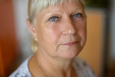 Mutfakta yaşlı bir kadının portresi. Sığ alan derinliğine sahip seçici odak.